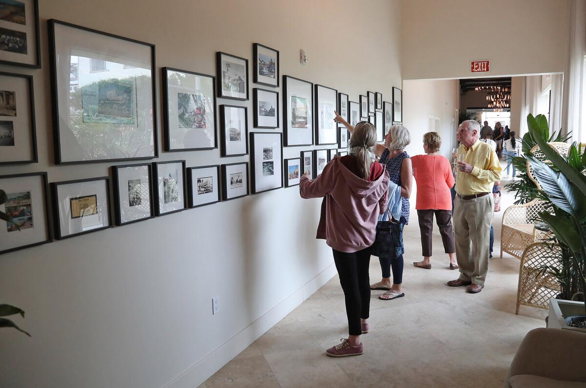 Guests gather to look at a wall of old photos of Laguna Beach in the hallway at the Hotel Laguna.