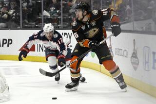 Ducks defenseman Ilya Lyubushkin controls the puck as Columbus Blue Jackets right wing Justin Danforth chases him