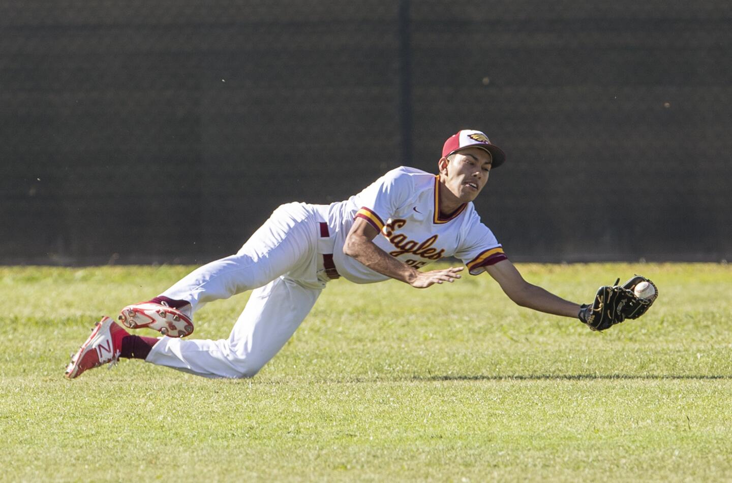 Estancia's Josh Caldales makes a diving catch on a ball hit by Costa Mesa's Miguel Rodriguez during an Orange Coast League game on Wednesday.
