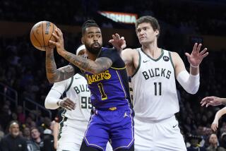 Lakers guard D'Angelo Russell controls the ball in front of Milwaukee Bucks center Brook Lopez.