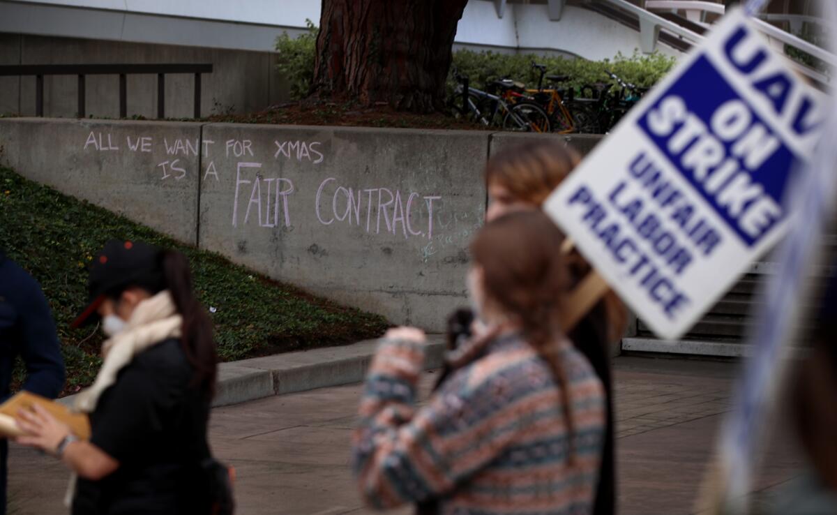 A message on a UC Irvine wall says "all we want for Christmas is a fair contract." 