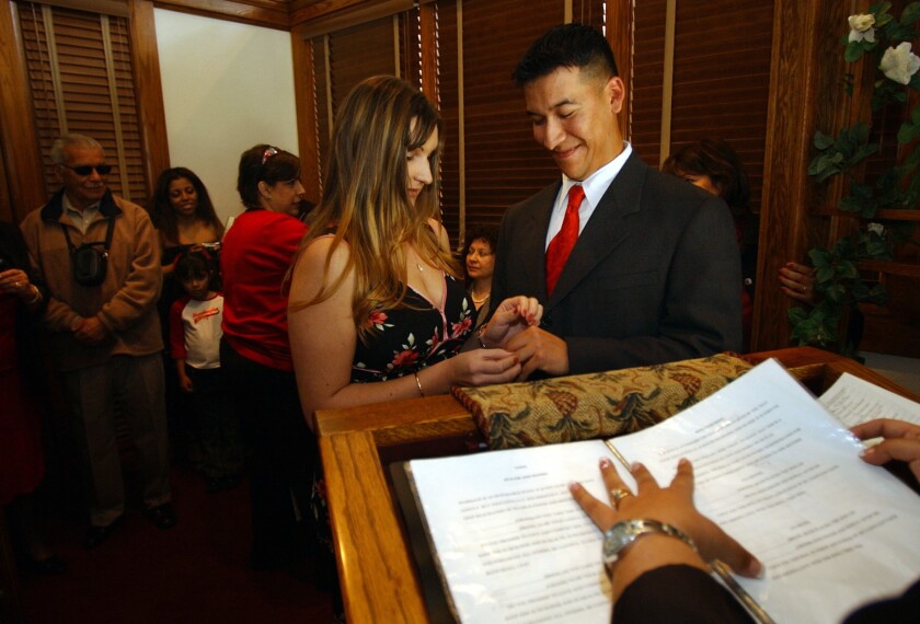 Natassia Grover places a ring on the hand of Ronnie Mendoza during a Valentine's Day wedding ceremony in 2004 at the Old Orange County Courthouse in Santa Ana.