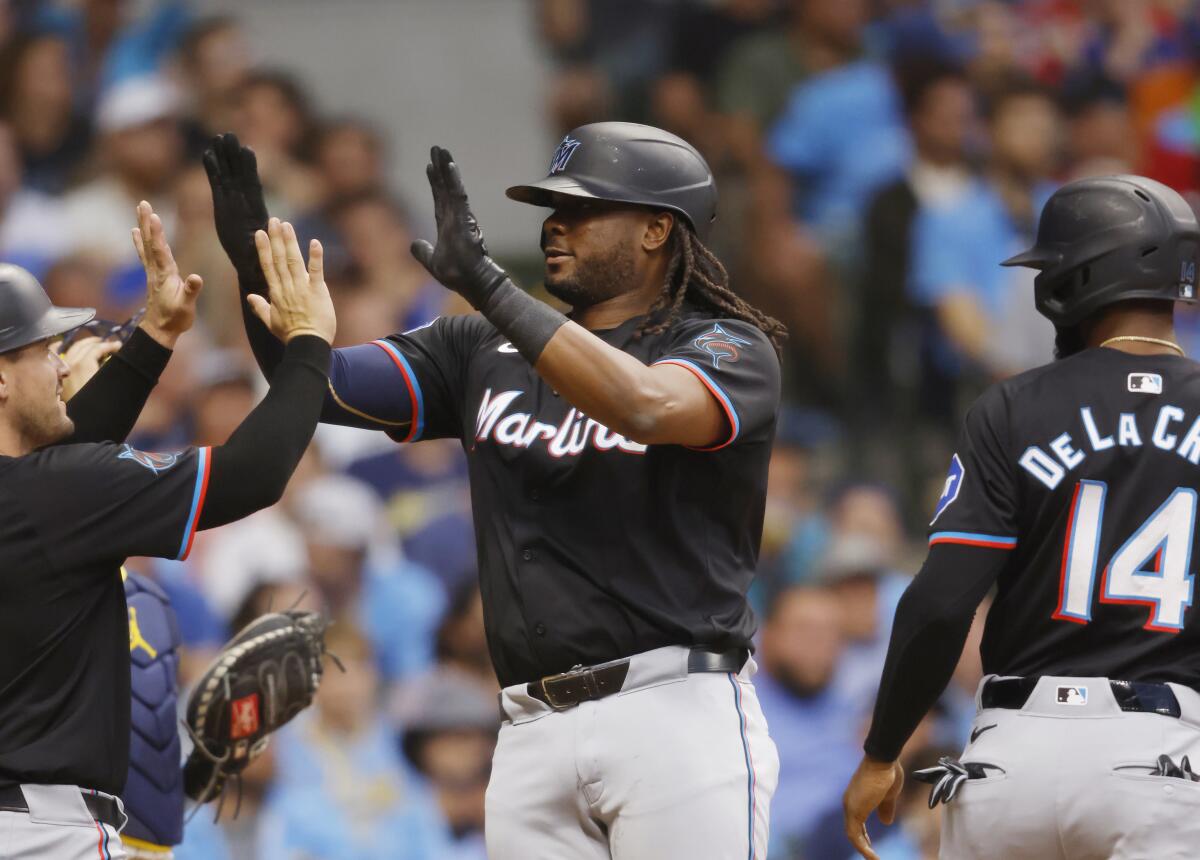 Josh Bell, de los Marlins de Miami, es felicitado por Nick Fortes