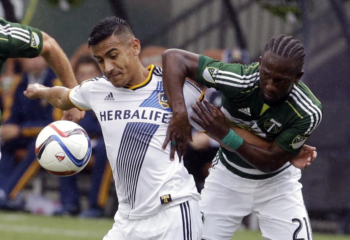 Galaxy forward Jose Villarreal, left, and Timbers midfielder Diego Chara battle for the ball in the first half Sunday.