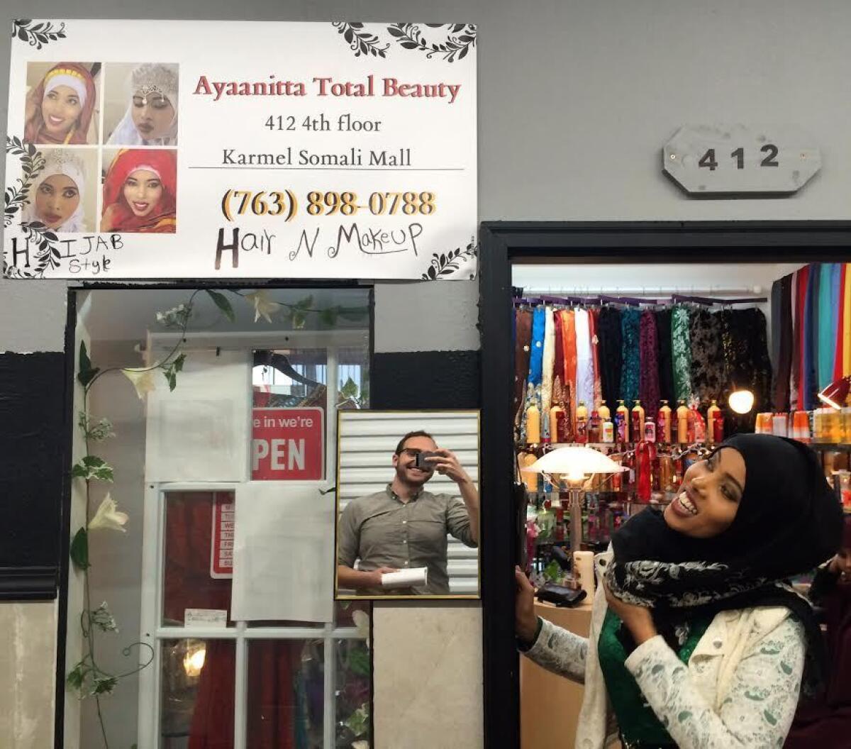 Ayan Aden poses in front of her beauty store in Minneapolis.