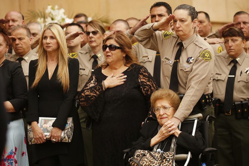 LOS ANGELES, CA - JUNE 24, 2019 - Family including Deputy Solano's GodMother Sallome Yanez, right, and Los Angeles County Sheriff Deputies salute the casket during a memorial service for Los Angeles County Sheriff?s Deputy Joseph Solano Monday morning June 24, 2019 at Cathedral of Our Lady of the Angels in Los Angeles. Deputy Solano was shot in the head at an Alhambra fast-food restaurant in an apparently unprovoked attack two weeks ago. (Al Seib / Los Angeles Times)
