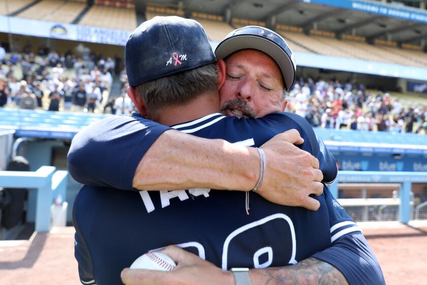 LOS ANGELES, CA - MAY 27: Birmingham Charter starting pitcher Kaden Taque (18), left, celebrates with Head Coach Matt Mowry, right, after defeating Carson 3-1 in the CIF LA City Section Open Division Baseball Championship at Dodger Stadium on Saturday, May 27, 2023 in Los Angeles, CA. Birmingham Charter won 3-1 over Carson. Head Coach Matt Mowry's wife Amy Gail Mowry, 51, passed away on September 26th, 2022, as a result of a 7  year battle with triple negative breast cancer. (Gary Coronado / Los Angeles Times)