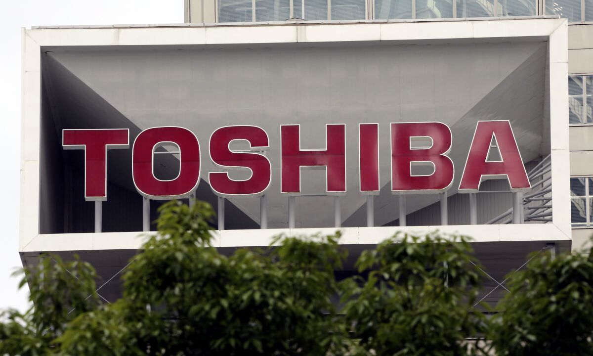 FILE - This photo shows the company logo of Toshiba Corp. displayed in front of its headquarters in Tokyo on May 26, 2017. Embattled Japanese technology conglomerate Toshiba said Friday it is restructuring to improve its competitiveness, spinning off its energy infrastructure and computer devices businesses. (AP Photo/Koji Sasahara, File)