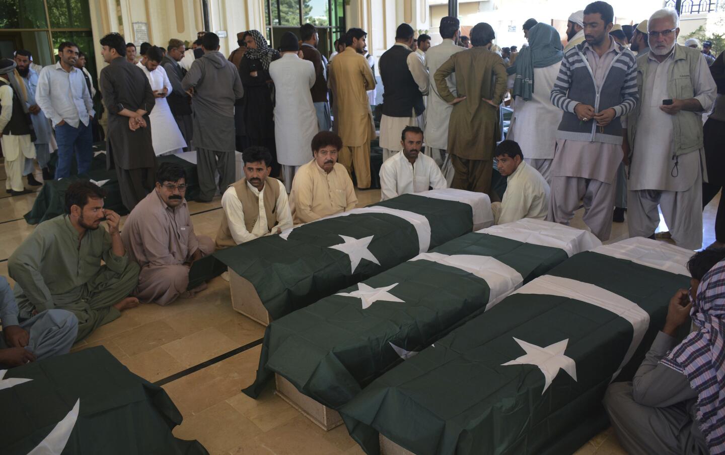 People wait to receive the bodies of family members who died in an attack on the Police Training Academy in Quetta, Pakistan. Militants wearing suicide vests stormed the Pakistani police academy overnight, killing dozens of people, mostly police cadets and recruits.