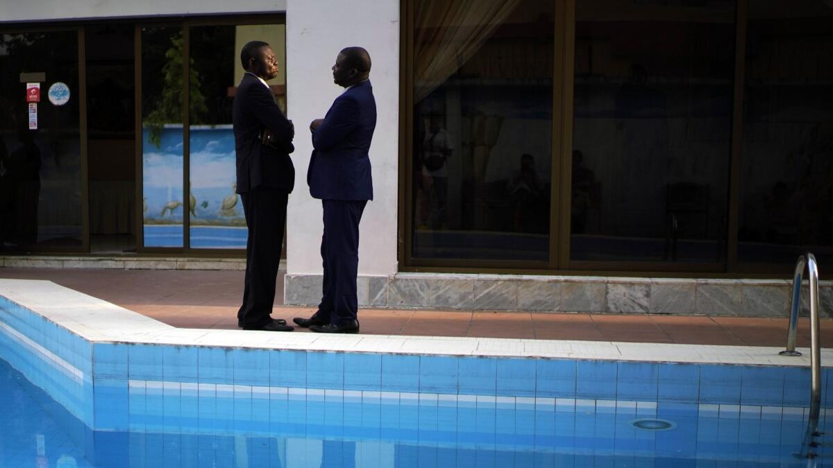 Members of the Congolese opposition coalition Lamuka talk while waiting for a statement to be issued on the timing of the release of the presidential election results in Kinshasa on Saturday.
