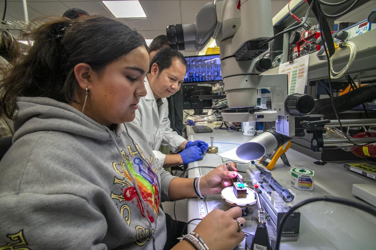 Raul Saragon of Biosense Webster explains to Buena Park High student Yandery Perez about soldering to a PCB.