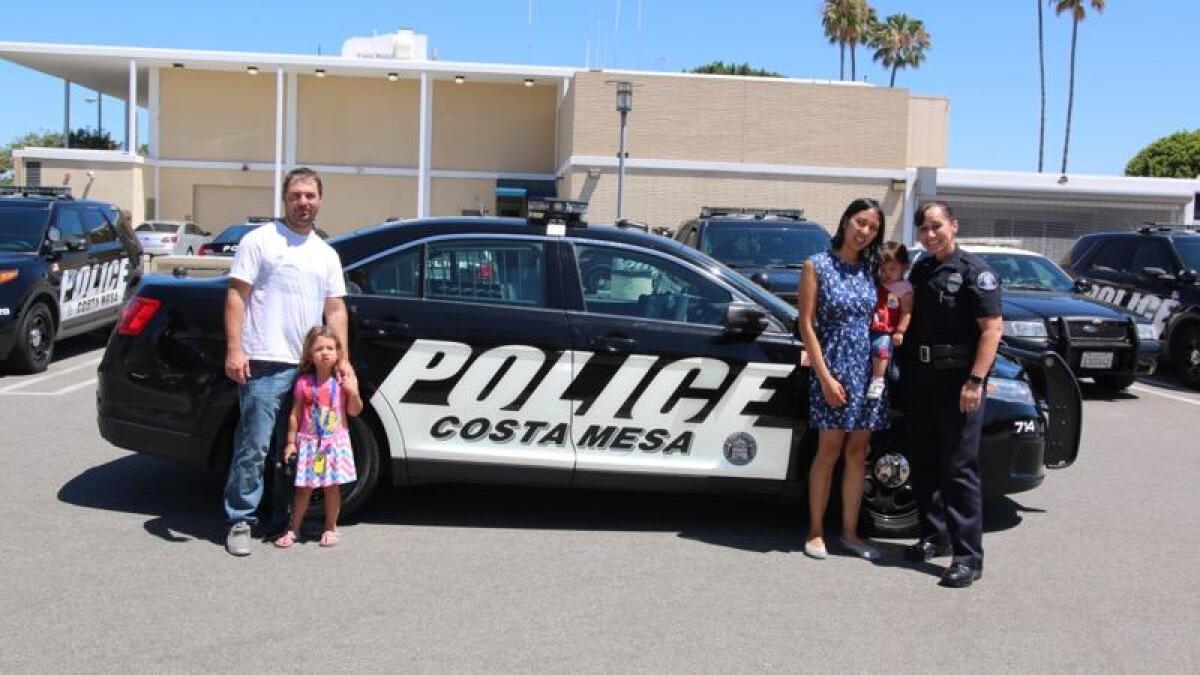 Joyce LaPointe of the Costa Mesa Police Department (right) poses for a photo with the family of a girl she helped deliver. 