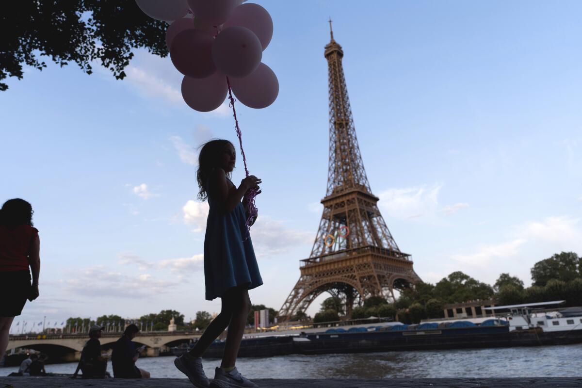 Jenna Baltes, 8, of St. Paul, Minn., holds balloons while w 