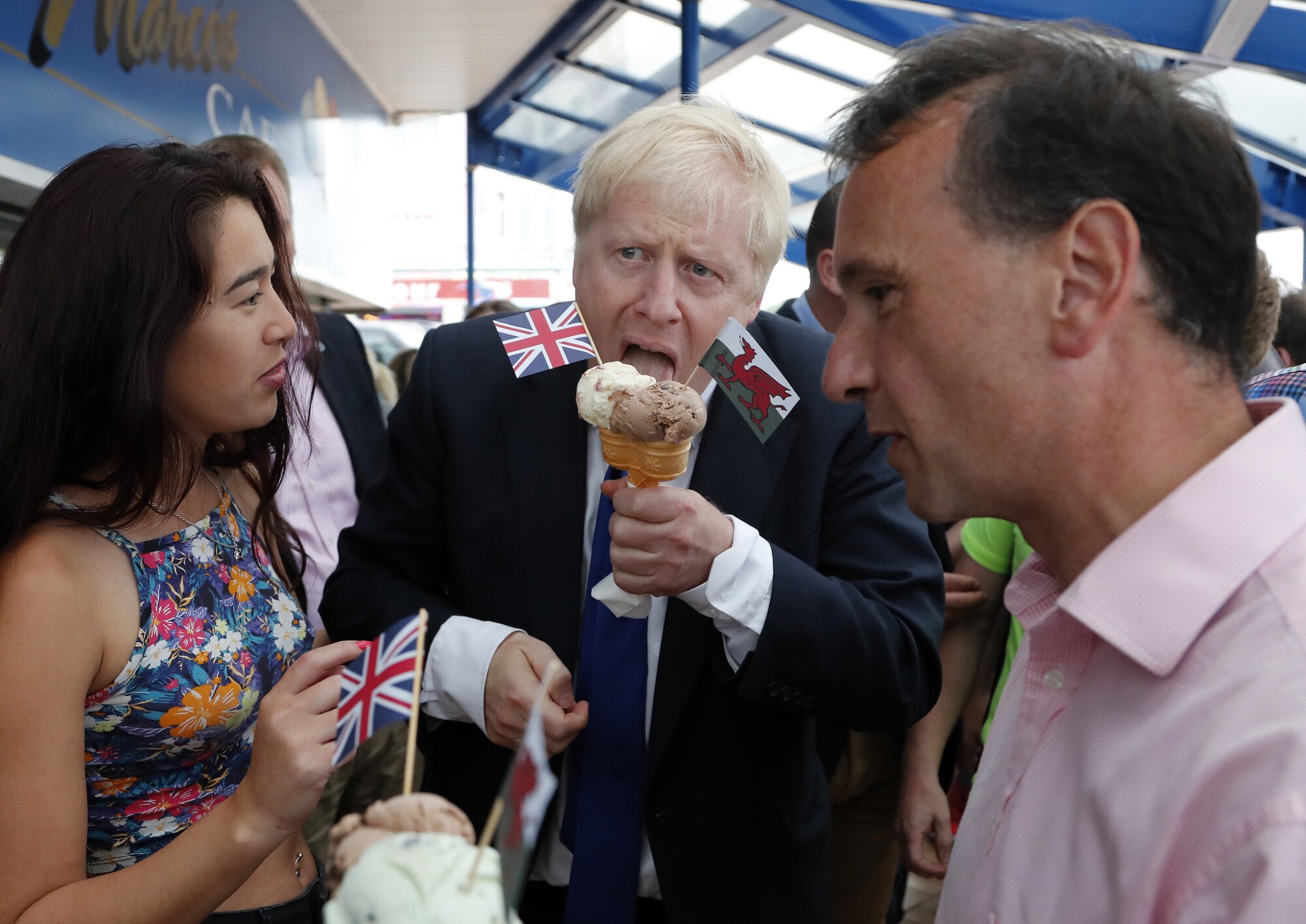 Conservative Party leader candidate Boris Johnson (center) eats ice cream on Barry Island, Wales, 2019.