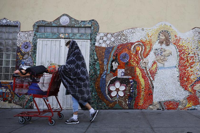 SAN DIEGO, CA - MARCH 25: A homeless man walks by God's Extended Hand Ministries on the corner of Island Avenue and 16th Street on Thursday, March 25, 2021 in San Diego, CA. The center, which has offered homeless services for 40 years, is facing several code violations and may have to shut down. (K.C. Alfred / The San Diego Union-Tribune)