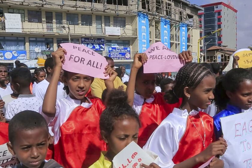 Children from a local martial arts and fitness center hold peace signs at a street carnival organized by the Tigray Development Association in support of the recent peace deal agreed between the Ethiopian federal government and Tigray forces, in Mekele, the capital of the Tigray region, in northern Ethiopia on Saturday, Nov. 26, 2022. (AP Photo)
