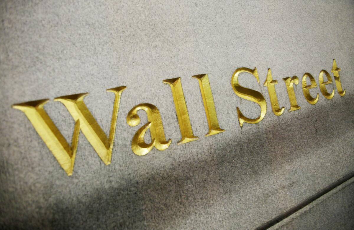 A Wall Street address is carved into the side of a building in New York. U.S. stock indexes were flat early Thursday in advance of a much-anticipated Federal Reserve decision on interest rates.