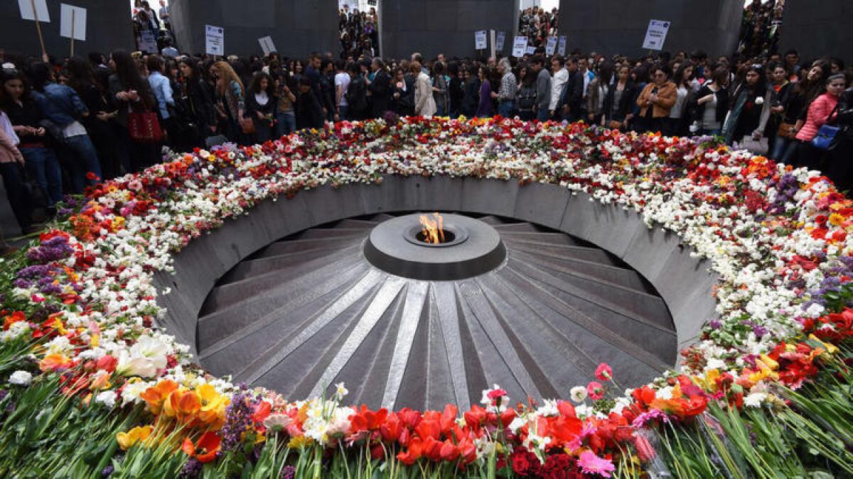People lay flowers at the Tsitsernakaberd Armenian Genocide Memorial in Yerevan, Armenia, on Tuesday.