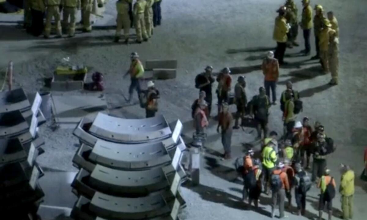 A high-angle view of workers in neon vests and helmets