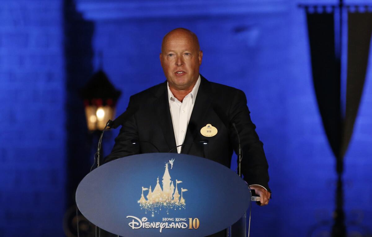 A man stands at a lectern that includes the word "Disneyland." 