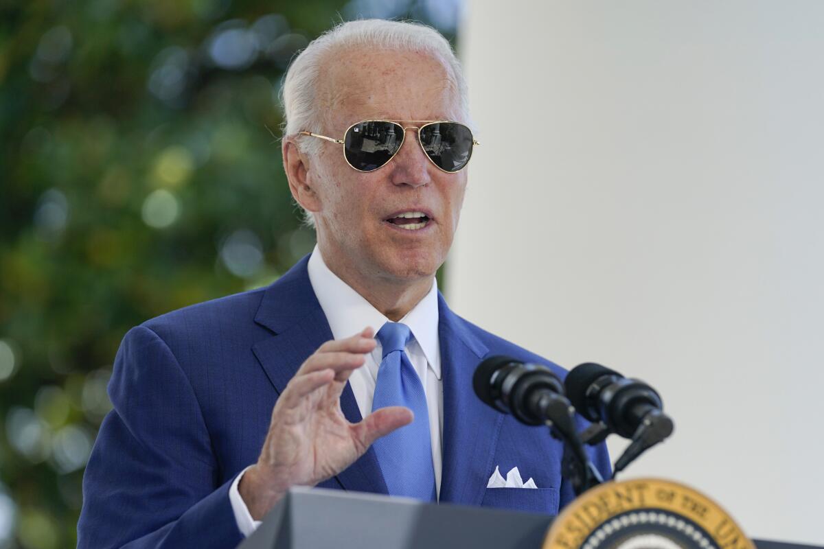 President Biden speaking outside at a lectern with the presidential seal.