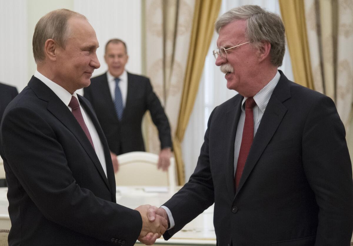 Russian President Vladimir Putin shakes hands with U.S. national security advisor John Bolton in Moscow in June 27.