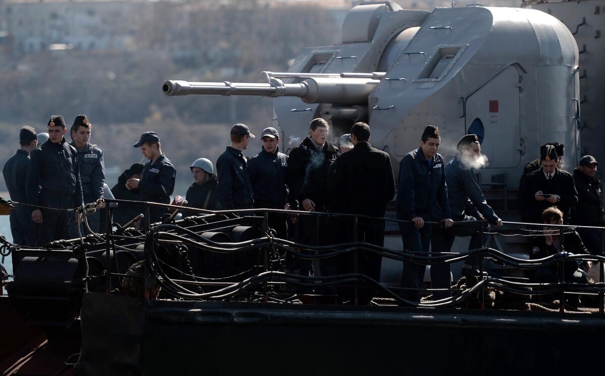 Ukrainian soldiers stand guard on board the navy corvette Ternopil as Russian forces patrol nearby in the harbor of Sevastopol, Ukraine, on March 5, 2014.