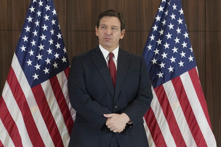 Governor Ron DeSantis listens to others during a news conference where he spoke of new law enforcement legislation that will be introduced during the upcoming session, Thursday, Jan. 26, 2023, in Miami. (AP Photo/Marta Lavandier)
