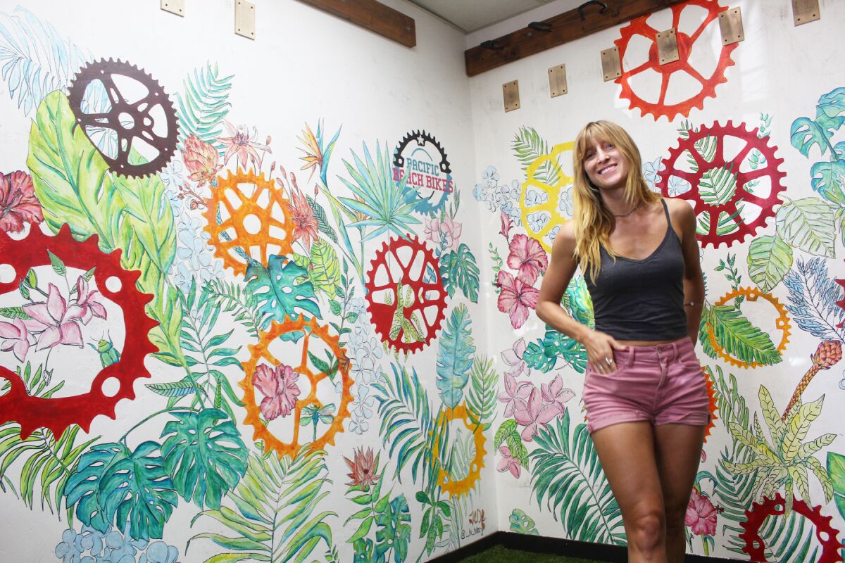 Artist Hilary Dufour in front of the artwork she completed for San Diego Cyclery (formerly Pacific Beach Bikes).