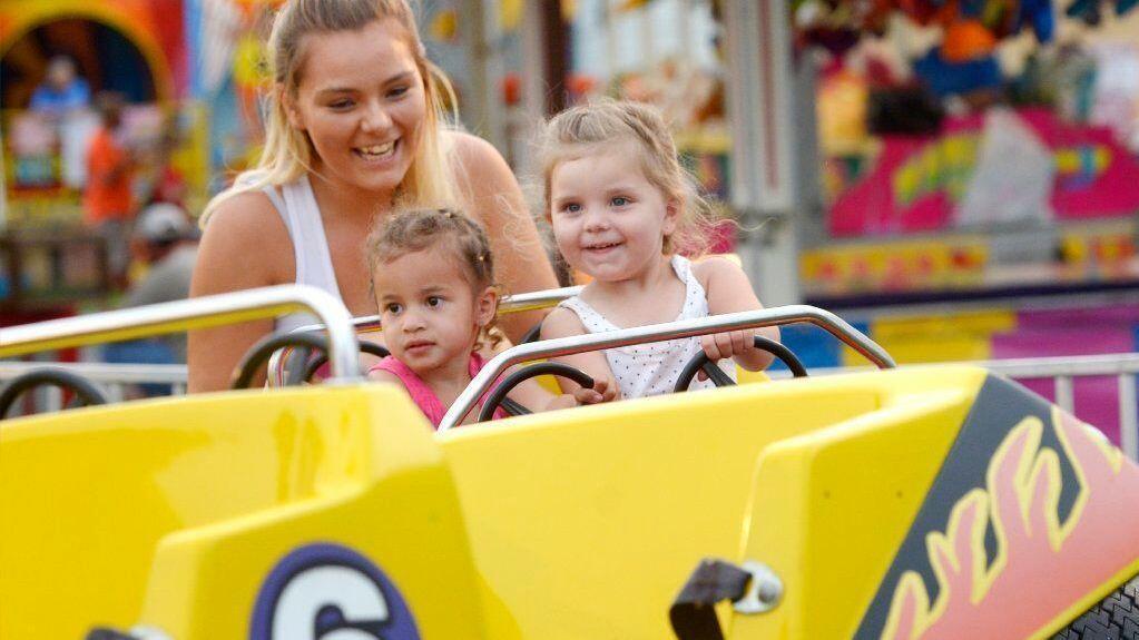 Hannah Fields of Waynesboro, Pa. rides the Baja Buggy with her niece Nevaeh Farmer, left, and daughter Serenity Mitchem, both 3, on the midway of the Union Bridge fire company carnival Tuesday, May 28, 2019.