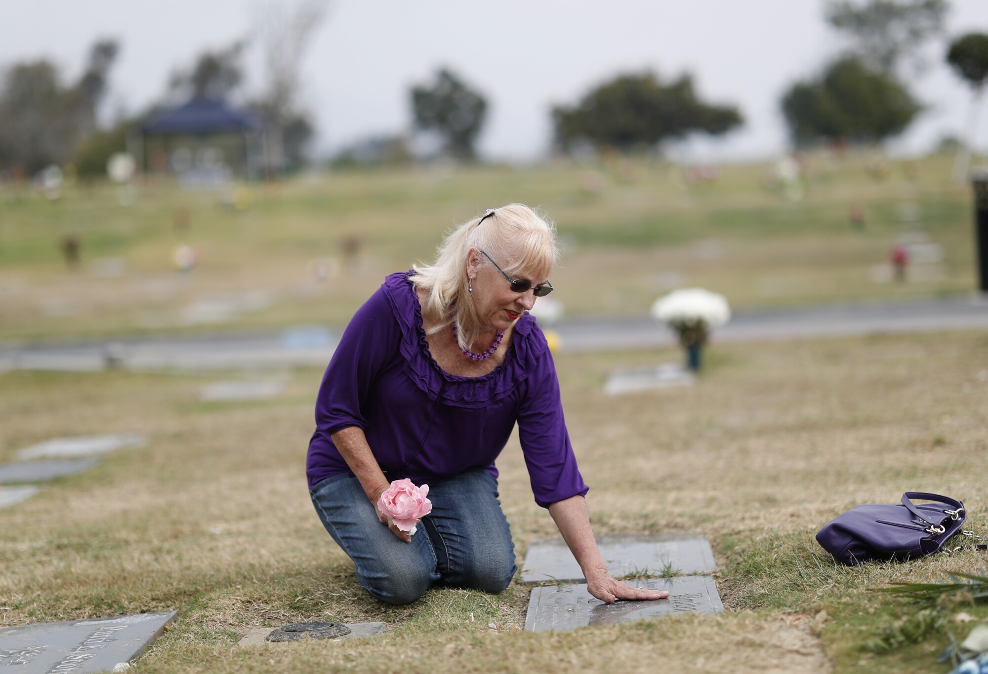 Rebecca Brown visits her husband's grave to place a rose on Nov. 16, 2021.