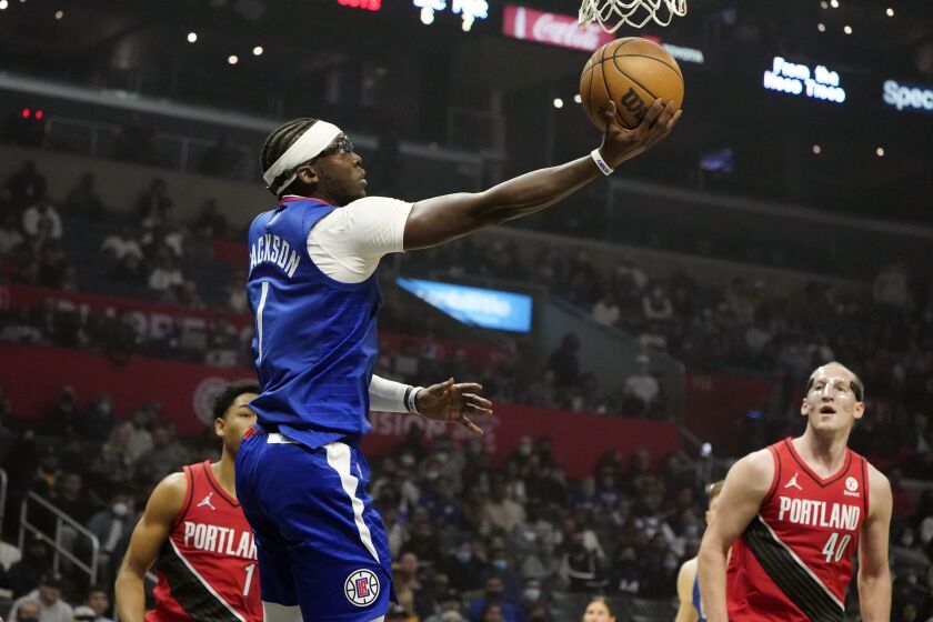 Los Angeles Clippers guard Reggie Jackson, top center, scores past Portland Trail Blazers guard Anfernee Simons (1) and center Cody Zeller (40) during the first half of an NBA basketball game Monday, Oct. 25, 2021, in Los Angeles. (AP Photo/Marcio Jose Sanchez)