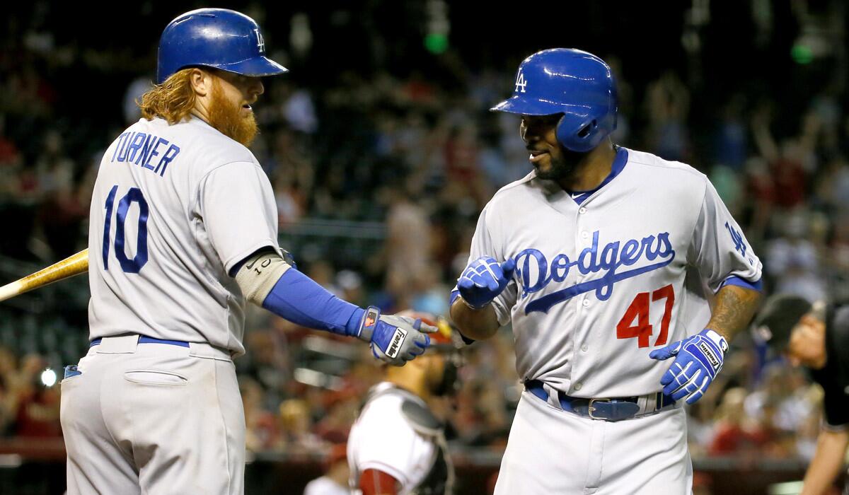 Los Angeles Dodgers' Howie Kendrick, right, greets teammate Justin Turner after hitting a solo home run against the Arizona Diamondbacks during the 10th inning on Tuesday.