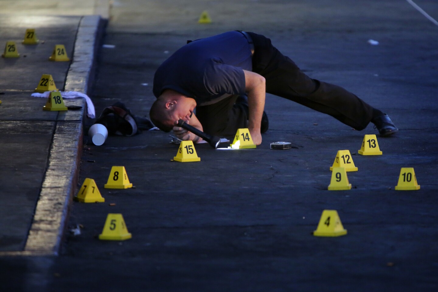 San Bernardino police examine the scene of a fatal shooting in a parking lot.