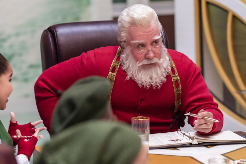 Santa holding a pen while conducting a business meeting