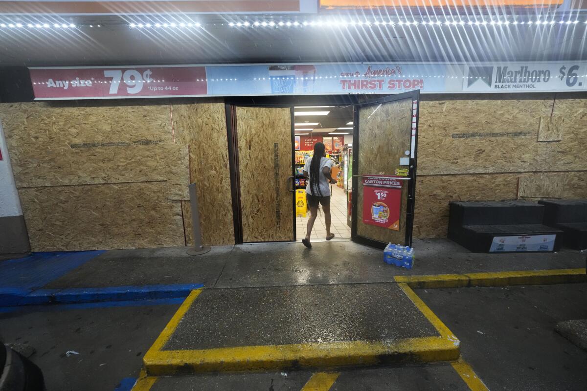 A customer enters a gas station that is boarded up in anticipation of Hurricane Francine, in Morgan City, La.