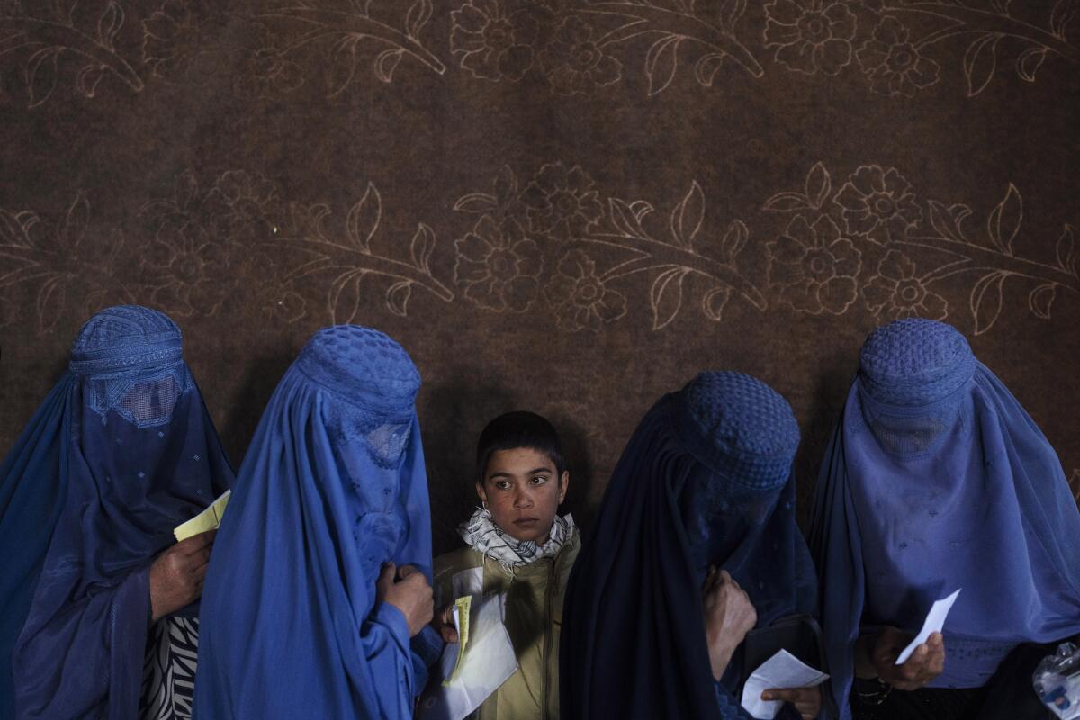 En esta imagen de archivo, mujeres afganas esperan para recibir dinero en efectivo 