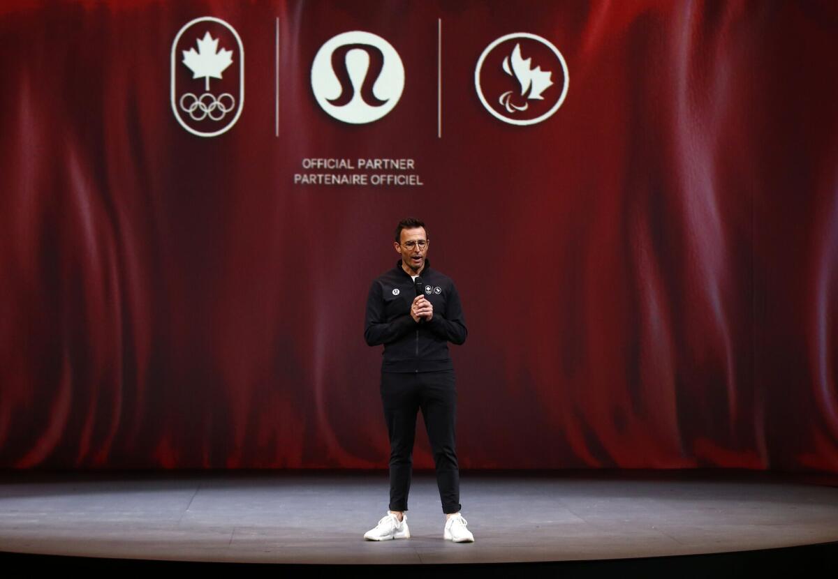 Calvin McDonald stands on a stage wearing a black outfit