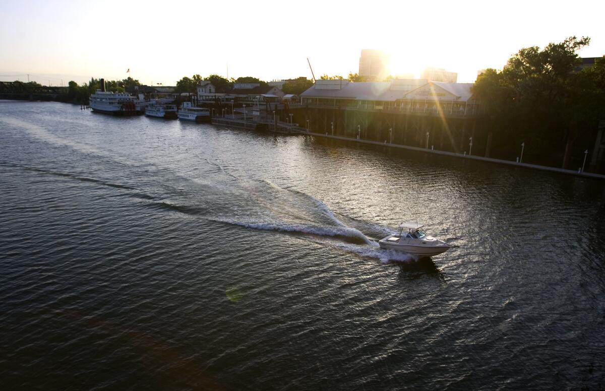 A small craft makes its way south on the Sacramento River. A man died when his excavator fell into the river Monday.