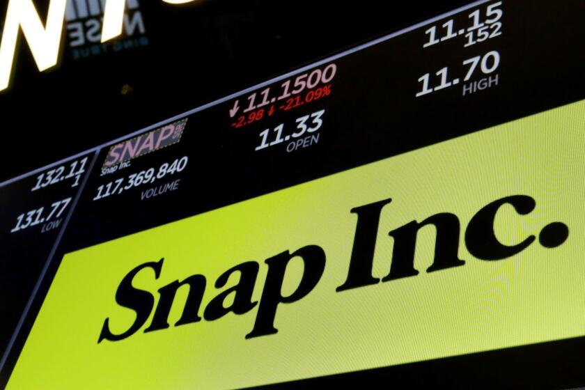The logo for Snap Inc. appears above a trading post on the floor of the New York Stock Exchange, Wednesday, May 2, 2018. Snap skidded 21 percent after its first-quarter revenue fell far short of estimates. The company said its redesign, which some users have slammed, was one of the reasons for the slip. (AP Photo/Richard Drew)