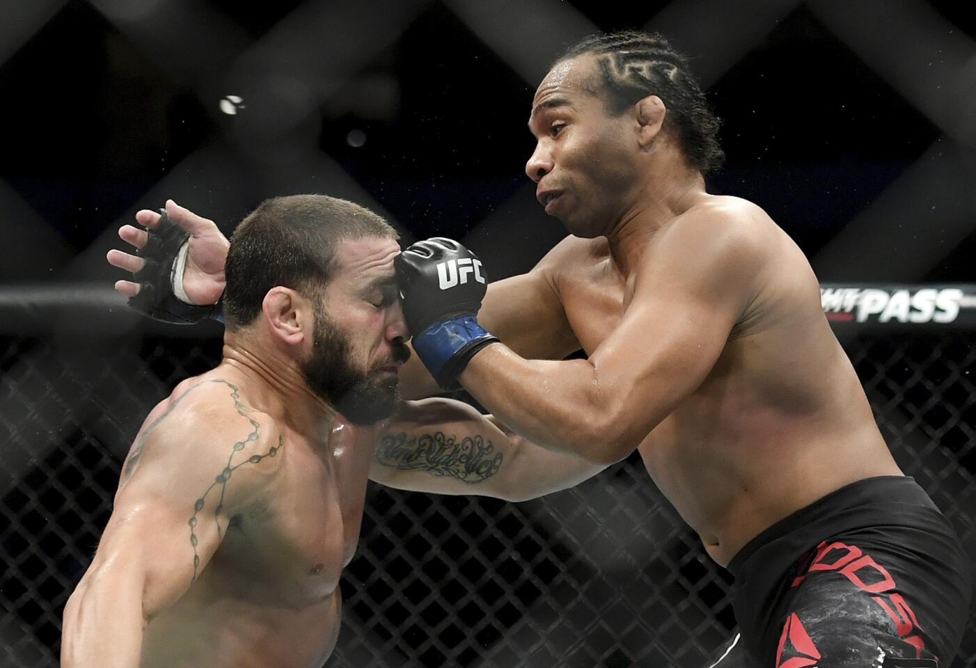 John Dodson, right, punches Jimmie Rivera during their bantamweight mixed martial arts bout at UFC 228 on Saturday, Sept. 8, 2018, in Dallas. (AP Photo/Jeffrey McWhorter)