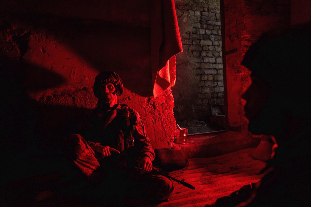 Ukrainian servicemen of Khartia battalion take cover in a shelter at the frontline near Kharkiv, Ukraine, on Tuesday