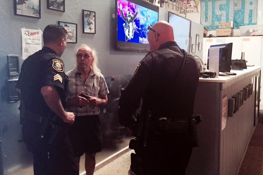 San Joaquin County Sheriff's deputies talk with Bill Dause, the owner of the Lodi Parachute Center in Lodi, Calif.