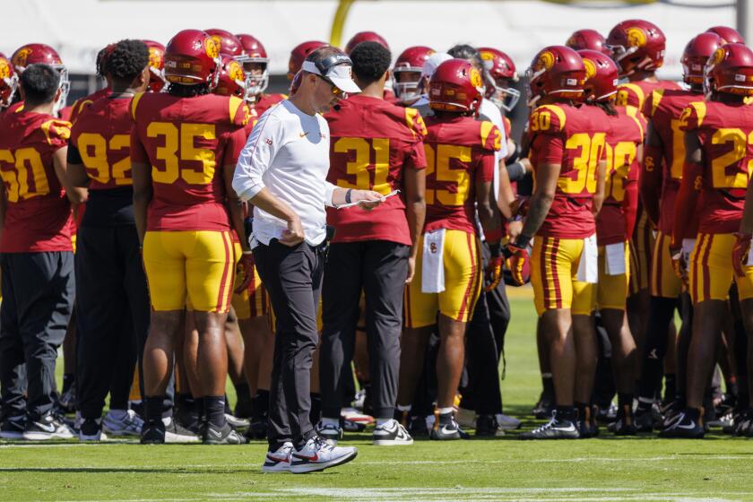 Trojans  coach Lincoln Riley studies his play card during a time out against Wisconsin.