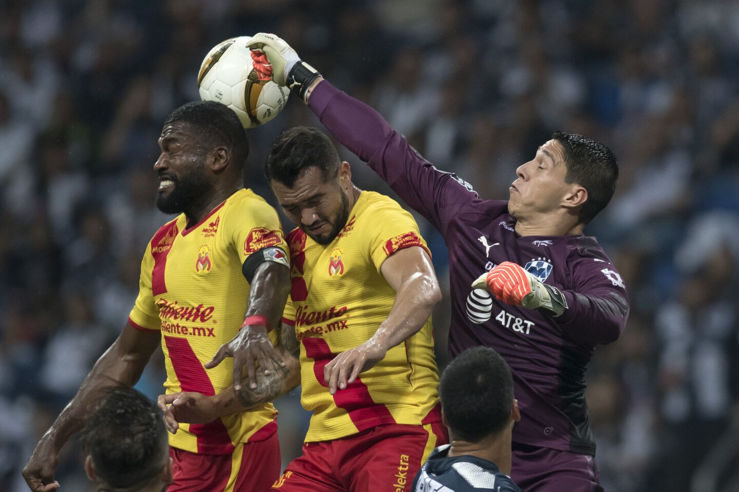 El portero Hugo González (d) de Monterrey disputa el balón con Mario Osuna (c) y Gabriel Achilier (i) de Monarcas de Morelia.