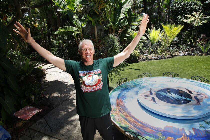 |06.25.2015 --San Diego, CA_Professional basketball legend Bill Walton, who has seen more concerts by The Grateful Dead than almost anyone, will play a major role at the Dead's upcoming 50th anniversary farewell tour heading to the Bay are and Chicago this summer. Here he poses by a Grateful Dead-inspired table in his Hillcrest backyard. MANDATORY CREDIT: San Diego Union-Tribune photo by John Gastaldo, 2015. |
