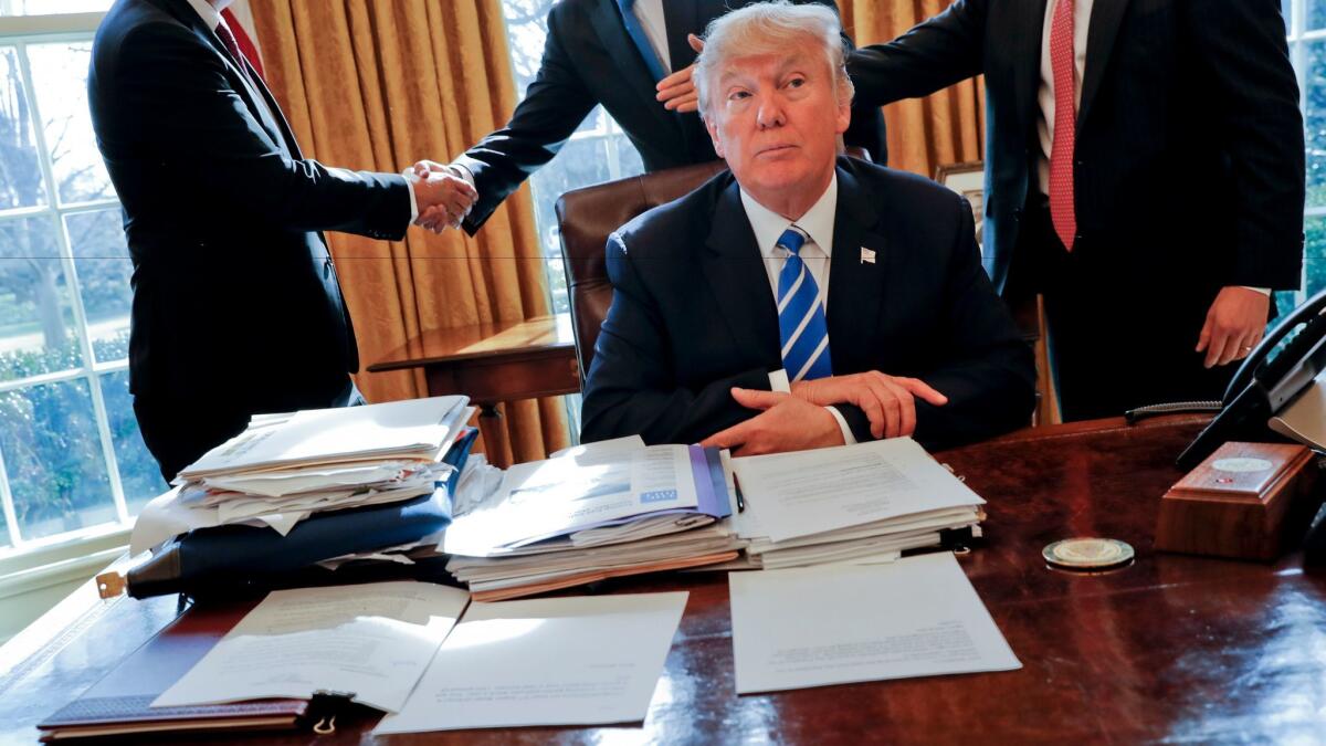 President Trump sits in the Oval Office after a meeting with Intel CEO Brian Krzanich and members of his staff.