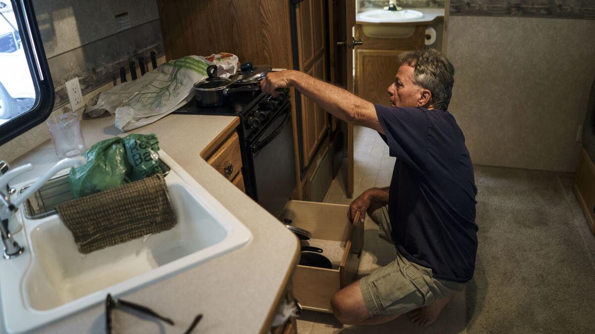 Raymond Taylor packs belongings in his temporary trailer. He and his wife Linda are preparing to move into a new home after being displaced by the Erskine fire for over a year.