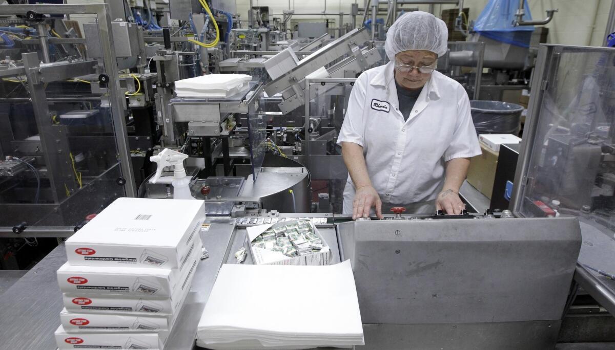 Rhonda Huskelhus monitors a machine packaging packets of butter at Grassland Dairy Products Inc. in Greenwood, Wis.
