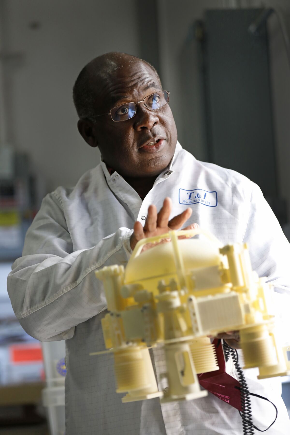 Ashitey Trebi-Ollennu, who worked on InSight since its early days, holds a model of the lander's seismometer.